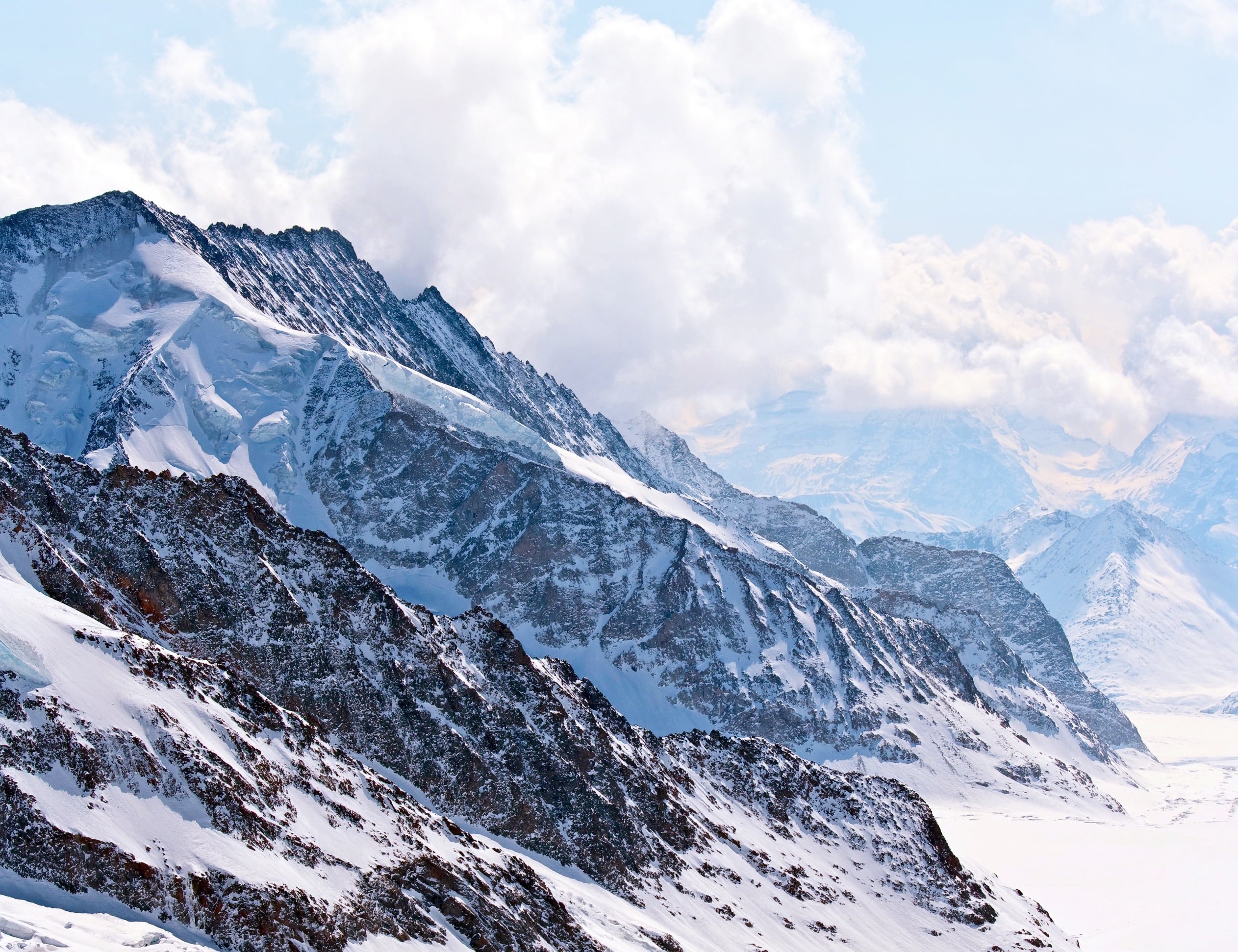 Dramatic snow-capped alpine ridge beneath clouds